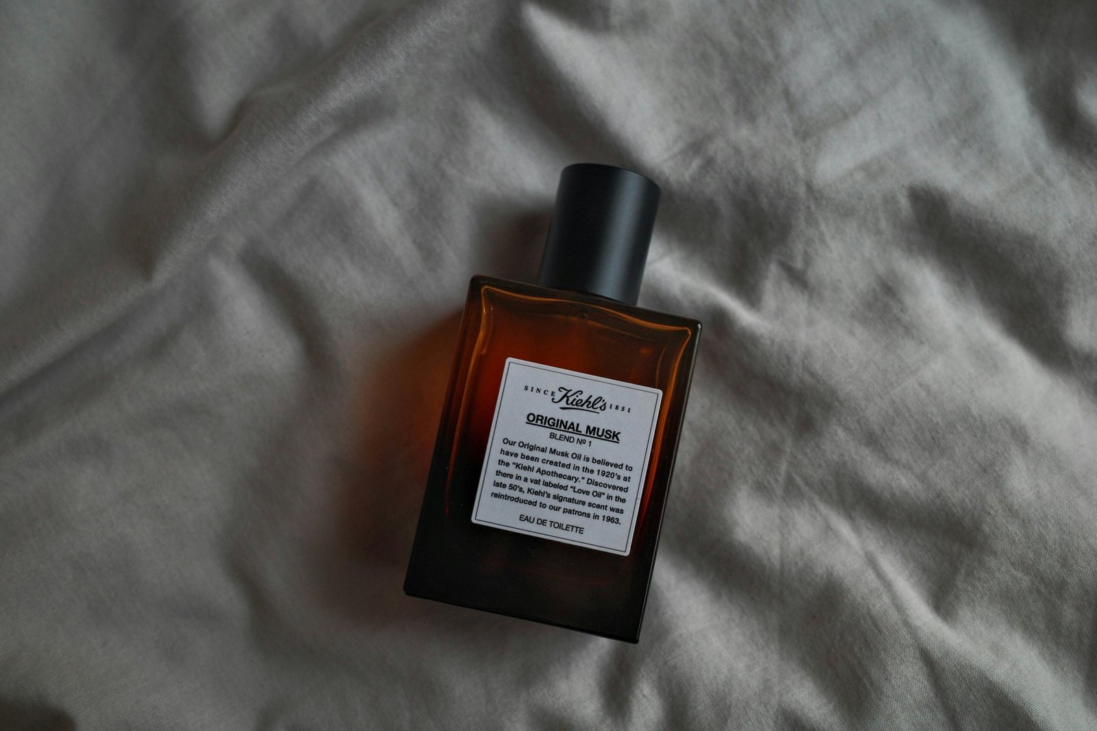 A person comparing different types of smooth coat shampoos at a pet store.