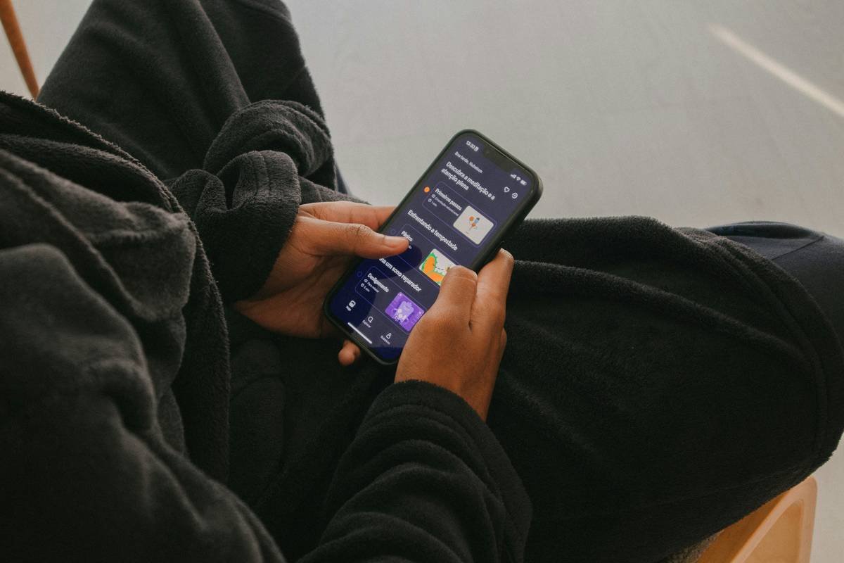 a person sitting on a chair holding a cell phone