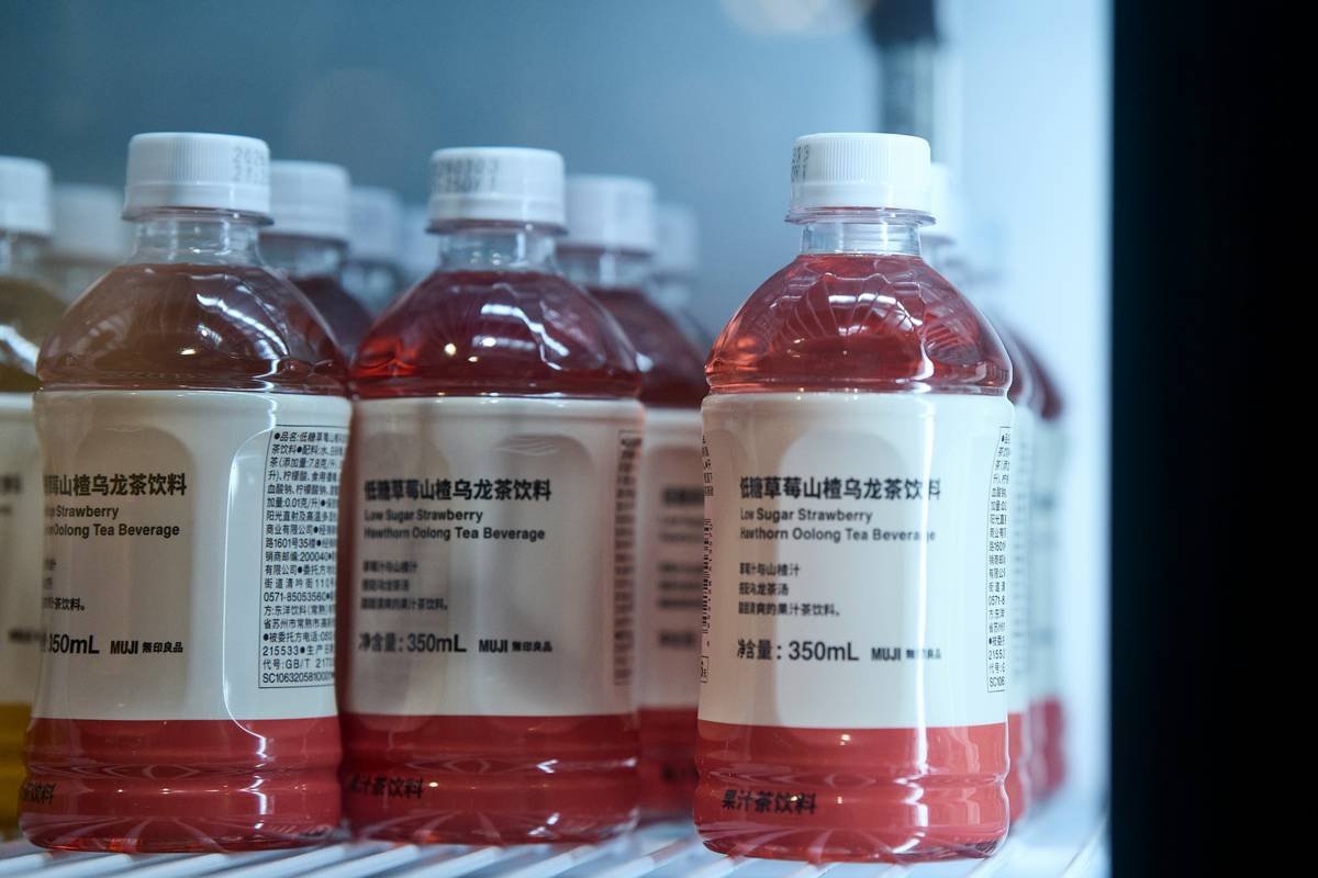Rows of red liquid bottles on a store shelf.